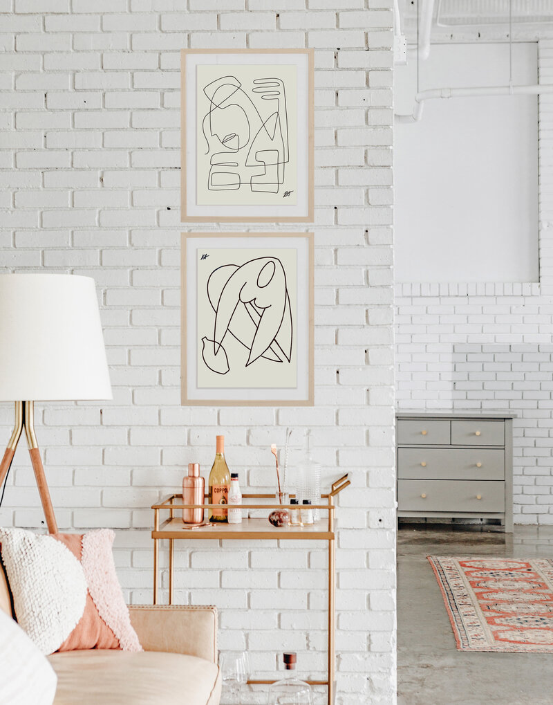 Interior of a brick wall with two framed prints hanging